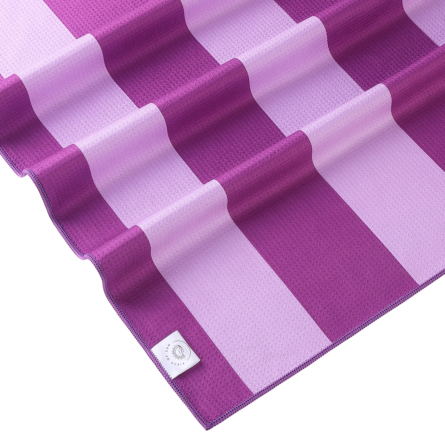 Detail van de wafelstructuur microvezel beach towel van Piece of Sun in paars en lichtroze – zacht, lichtgewicht en compact opvouwbaar.