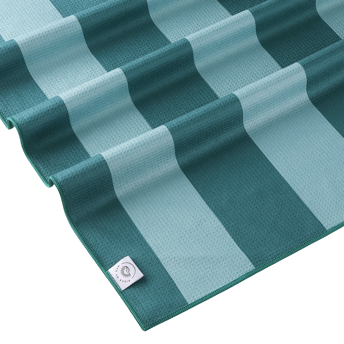 Detail van het turquoise-petrol gestreepte strandlaken van Piece of Sun. Luxe microvezel met wafelstructuur, gemaakt van 85% gerecycled materiaal – ultrazacht, lichtgewicht en sneldrogend.