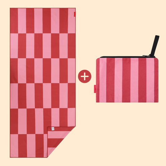 Set van Piece of Sun met roze-donkerroze microvezel strandlaken en bijpassend ritstasje. Gemaakt van 85% gerecycled materiaal, lichtgewicht, sneldrogend en ideaal voor strand of vakantie.