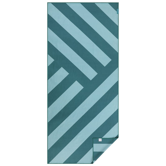 Groot microvezel strandlaken van Piece of Sun met diagonale strepen in turquoise en petrol. Duurzaam geproduceerd van 85% gerecycled materiaal, extra zacht, sneldrogend en ideaal voor strand, spa of vakantie.