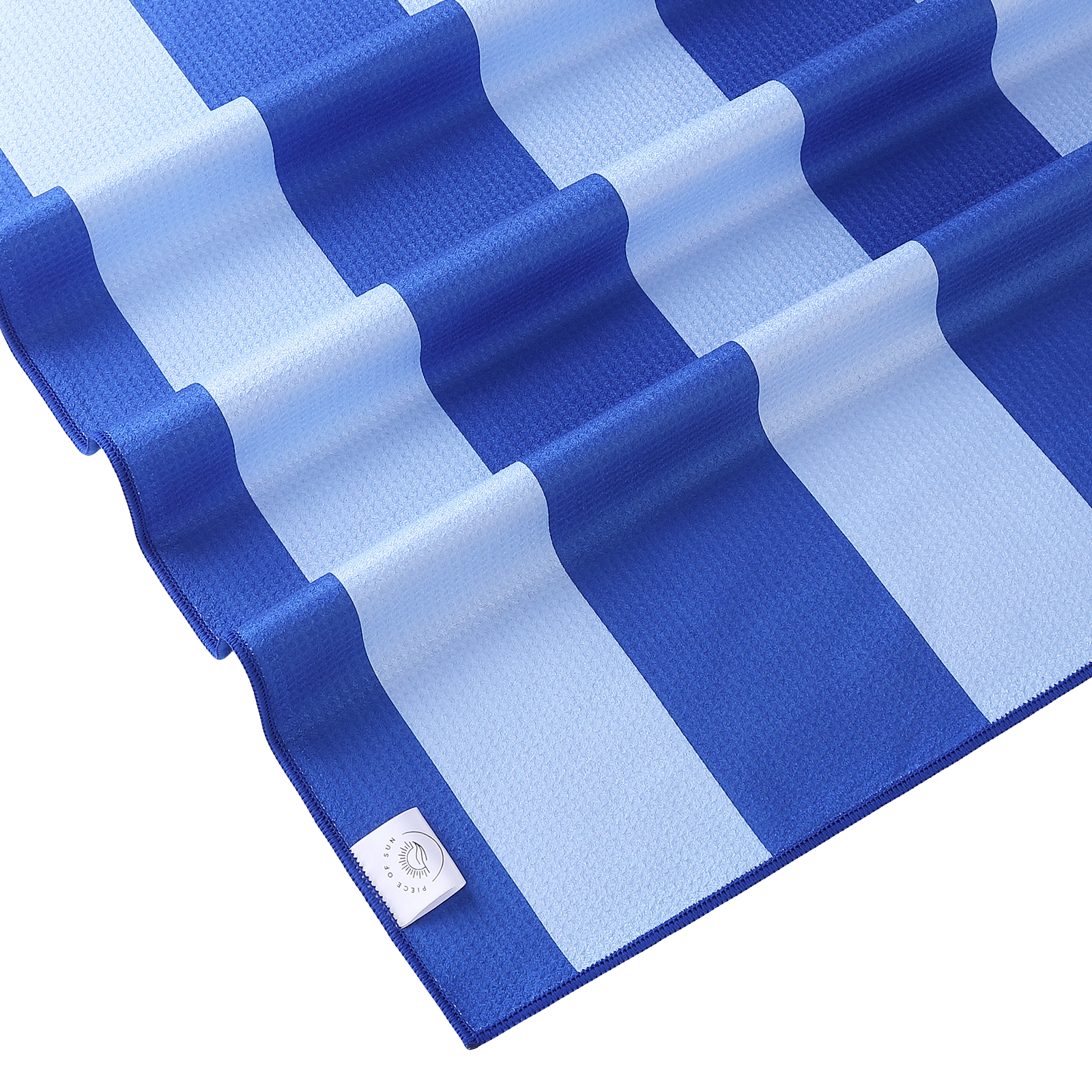 Detail van de microvezel wafelstructuur van de Piece of Sun strandhanddoek in blauw en lichtblauw, zacht, lichtgewicht en gemaakt van 85% gerecycled materiaal.